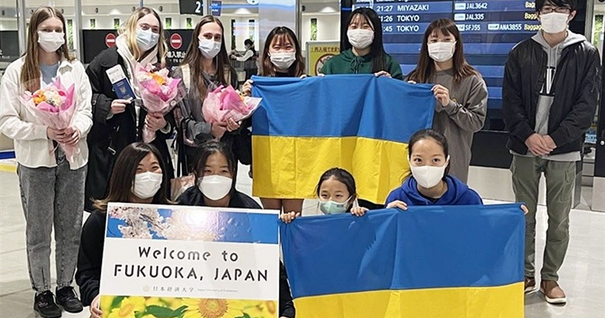 福岡空港に到着したウクライナ人学生と出迎えた日本経済大の学生たち＝15日夜
